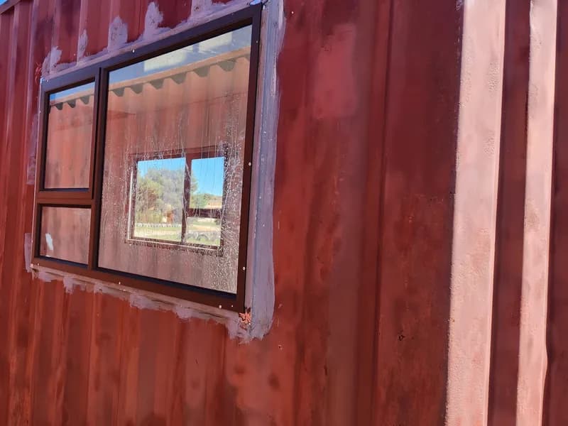 A framed window set into the corrugated wall