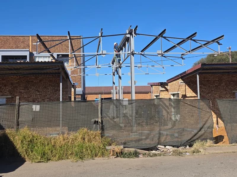 Steel frame going up behind site fencing